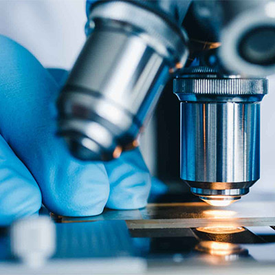 Environmental specialist examining an asbestos sample under a microscope in a laboratory.