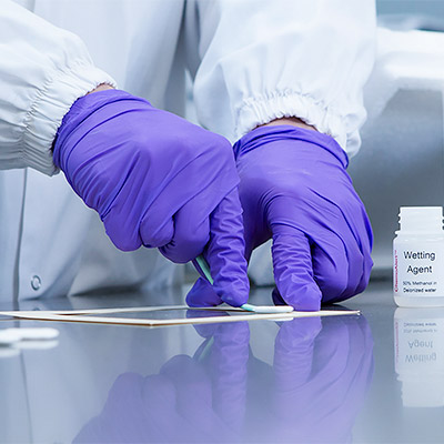 Laboratory specialist analyzing soot samples for fire and smoke contamination testing.